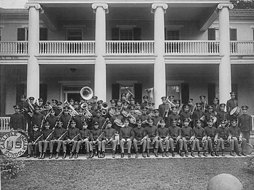 Carlisle Indian School Band Seated on Steps of a School Building