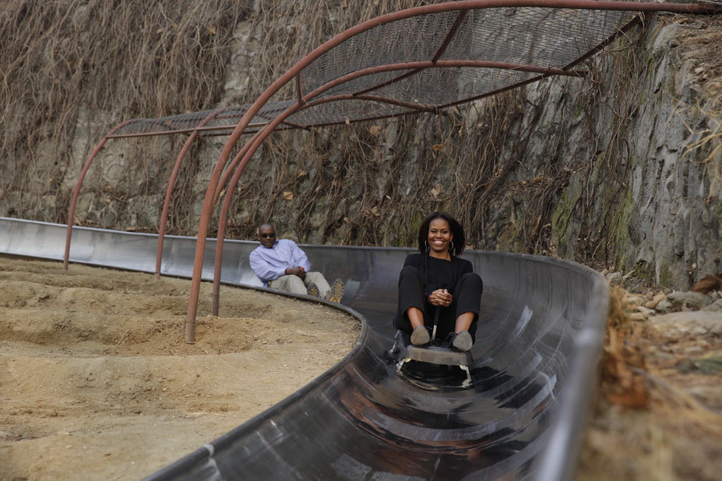 Michelle Obama and her Secret Service agent take a toboggan ride at the Great Wall of China